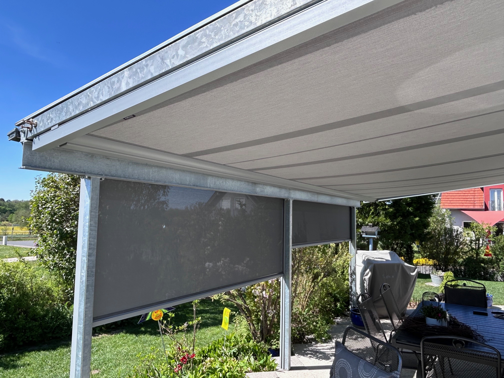 Eine Markise an der Terrassenüberdachung im Garten.