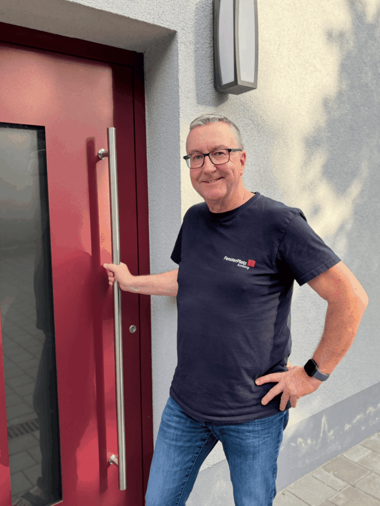 Heinz Reif der vor einer roten Haustüre steht.